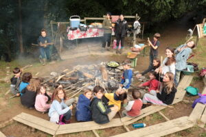 groupe d'enfants colonie autour ud feu de camp